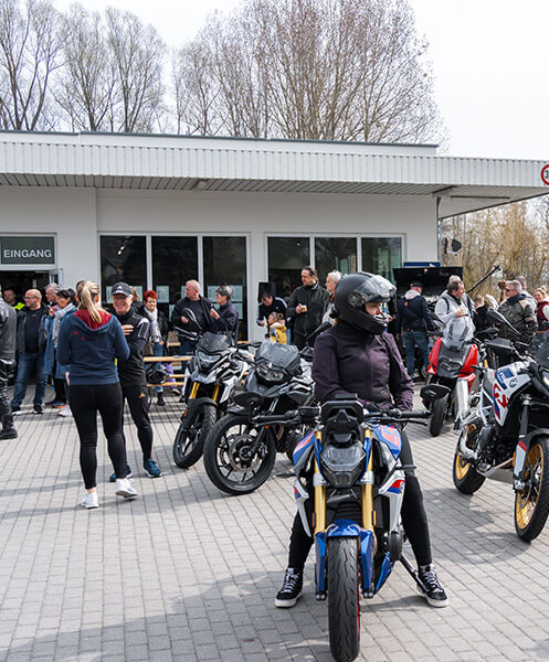 Frau auf Motorrad und andere MINI Wernecke Kunden beim Saisonstart 2025